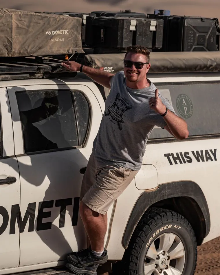 Dylan alongside the Dometic Hilux in the dunes